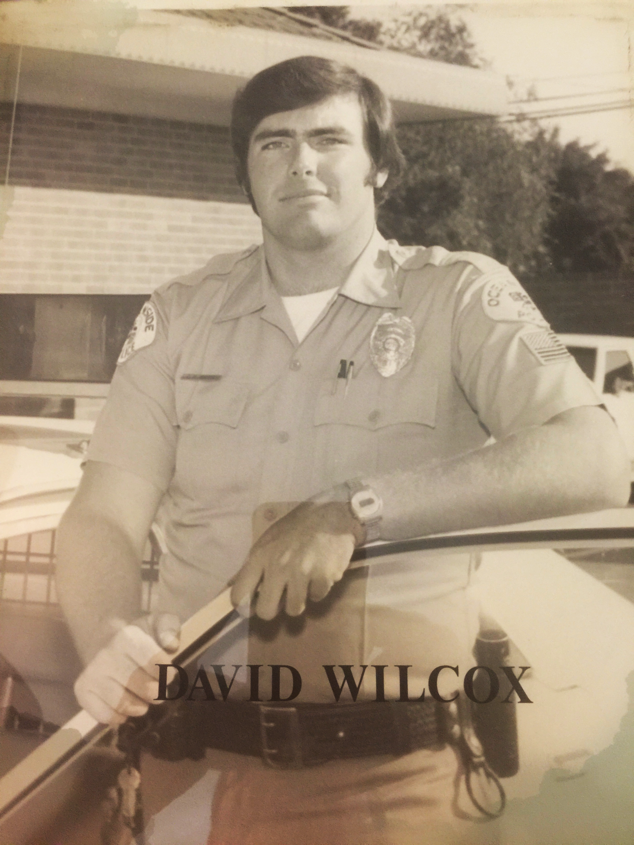 David R. Wilcox in police uniform beside a patrol motorcycle